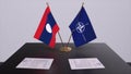 London, UK - 15 February 2023: Laos country national flag and NATO flag. Politics and diplomacy illustration