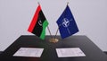 London, UK - 15 February 2023: Libya country national flag and NATO flag. Politics and diplomacy illustration