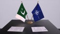 London, UK - 15 February 2023: Pakistan country national flag and NATO flag. Politics and diplomacy illustration