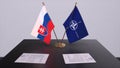 London, UK - 15 February 2023: Slovakia country national flag and NATO flag. Politics and diplomacy illustration