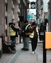 London UK February 2021 Three workers on the streets of London wearing yellow high visibility jackets on duty, one guy having a Royalty Free Stock Photo