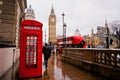 London, UK-FEBRUARY 12: Traditional red telephone box in the rainy day with the Big Ben and red bus in the background Royalty Free Stock Photo