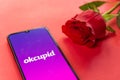 London, UK - 6 january 2021: okcupid dating app logo closeup on mobile phone with red rose. Concept of online dating . Romantic