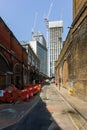 London, UK - 27 July, 2018: Vertical photo. View of the construction of a skyscraper through an old dirty alley