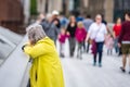 London, UK, July 14, 2019. Rear view of Elderly Woman in yellow coat standing on the Millennium Bridge Royalty Free Stock Photo