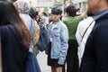 A short-haired brunette girl with a chain around her neck, in a short black skirt, white T-shirt and blue denim jacket sneaks Royalty Free Stock Photo