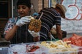 Woman preparing a tropical drink at a market stall in Portobello