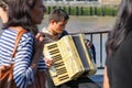 A young busker performing accordion on a crowd street at South B