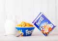 LONDON, UK - JUNE 01, 2018: Box of Kellogg`s Frosties Breakfast Cereal with milk and plate on white wood. Royalty Free Stock Photo