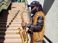 London, UK - June 21 2018 - A busker plays the saxaphone in London, at the Paddington Green underpass