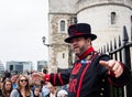 Cheerful Yeoman Warder leads visitors on a tour at the Tower of London Royalty Free Stock Photo