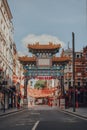 Ornamental gate with Qing Dynasty designs on empty street in Chinatown, London, UK