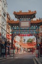 Ornamental gate with Qing Dynasty designs on empty street in Chinatown, London, UK