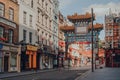 Ornamental gate with Qing Dynasty designs on empty street in Chinatown, London, UK