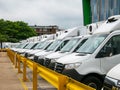 A long line of parked white transit vans, Mercedes Benz sprinter vans.