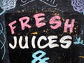 A shop hand painted board sign for advertising raw fresh juices.