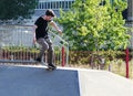 London, UK - June 28 2018: an unknown male youth performs skateboard tricks at a local skate park