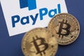 LONDON, UK - March 2021: Bitcoin cryptocurrency on a paypal online payment logo