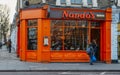 Exterior of Nando`s flame grilled PeriPeri chicken restaurant in Earl`s Court, London, UK. The chain is AfroPortuguese Royalty Free Stock Photo