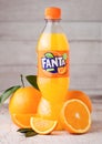 LONDON, UK - MARCH 31, 2018: Plastic bottle of Fanta orange soft drink on light wooden background with fresh oranges. Royalty Free Stock Photo
