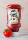 LONDON, UK - MARCH 10, 2018 : Plastic bottle of Heinz Ketchup on wood with raw tomato. Manufactured by H.J. Heinz Company Royalty Free Stock Photo