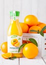 LONDON, UK - MARCH 31, 2018: Plastic bottle of Innocent orange juice with fresh raw oranges on white wood