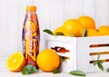 LONDON, UK - MARCH 31, 2018: Plastic bottle of Lucozade orange zero soft drink with fresh raw oranges in wood box