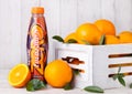 LONDON, UK - MARCH 31, 2018: Plastic bottle of Lucozade orange zero soft drink with fresh raw oranges in wood box.