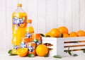 LONDON, UK - MARCH 31, 2018: Plastic bottles and aluminium tins of Fanta orange soft drink on white wooden background Royalty Free Stock Photo