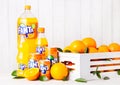 LONDON, UK - MARCH 31, 2018: Plastic bottles and aluminium tins of Fanta orange soft drink on white wooden background Royalty Free Stock Photo