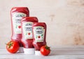 LONDON, UK - MARCH 10, 2018 : Plastic bottles of Heinz Ketchup on wood with raw tomatoes. Manufactured by H.J. Heinz Company