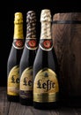 LONDON, UK - MAY 03, 2018: Cold bottles of Leffe beer next to wooden barrel on black background.Leffe is made by Abbaye de Leffe i Royalty Free Stock Photo