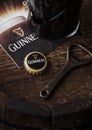 LONDON, UK - MAY 03, 2018: Original glass of Guinness draught stout beer on top of wooden barrel with bottle opener and beer coas Royalty Free Stock Photo