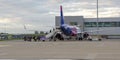 Passengers boarding Wizzair airplane at the London Luton airport. People getting into the aircraft