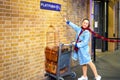 Unidentified people poses at platform 93/4 in King`s Cross Station