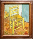 Van Gogh\'s Chair with Pipe. The painting shows a rustic wooden chair with a simple woven straw seat on a