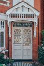 White stained glass front door of a traditional Edwardian house in London, UK, selective focus