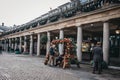 People sitting at a bench decorated with Christmas baubles in Co