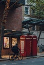 Red phone boxes in front of Sadlers Wells Theatre in London, UK, cyclist riding past Royalty Free Stock Photo