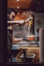 Seller serving pasta at The Cheese Wheel stand in Camden Market, London, UK