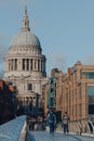 View of St. Pauls Cathedral from Millennium Bridge, London, UK, people walk in front, selective focus Royalty Free Stock Photo