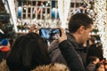 Woman takes photos inside Kingly Court decorated with Christmas lights, London, UK