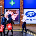 Boots Chemist Or Pharmacy Logo With People Walking Past