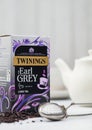 LONDON, UK - OCTOBER 21, 2020: Box of Twinings Earl Grey loose tea with ceramic teapot and vintage strainer infuser on white