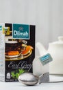 LONDON, UK - OCTOBER 21, 2020: Dilmah Earl Grey tea bag and box with ceramic teapot and vintage strainer infuser on white