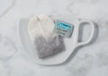 LONDON, UK - OCTOBER 21, 2020: Dilmah Earl Grey tea bag on ceramic plate with cup shape on white