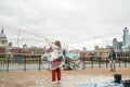 London, UK - October 2019: Giant soap bubbles show - street performers entertain tourists Royalty Free Stock Photo