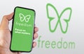 A hand holding a smart phone with Freedom app open on the screen
