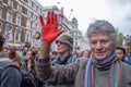 A man holds his red painted hand up while in a group of Extinction Rebellion protesters in London