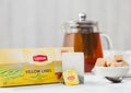 LONDON, UK - OCTOBER 21, 2020: Pack of Lipton Yellow Label black tea with tea bag and teapot with cane sugar on white